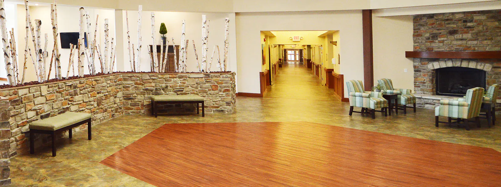 Benches and chairs in front of a fireplace in the lobby of a building